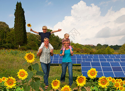 在太阳能电池板傍边的一家人图片
