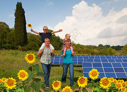 在太阳能电池板傍边的一家人图片
