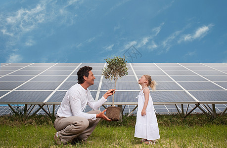 男人和女儿在太阳能板前图片