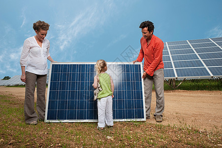 太阳能板前的家庭图片