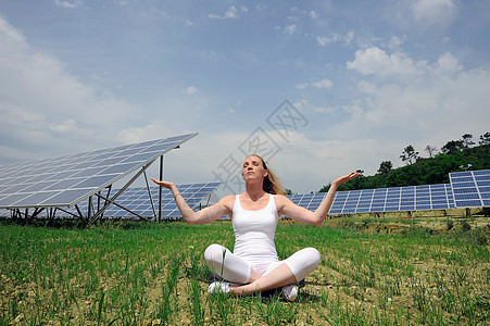 在太阳能板前做瑜伽的女人图片