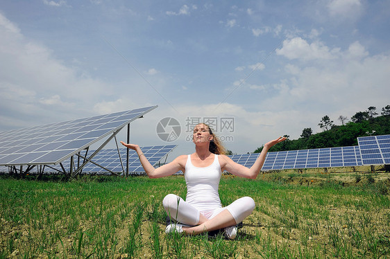 在太阳能板前做瑜伽的女人图片