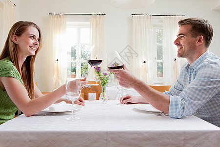 一对夫妇在餐厅用葡萄酒敬酒图片