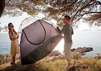 一对夫妇在海边搭帐篷图片