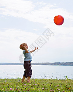 在湖边玩球的男孩图片