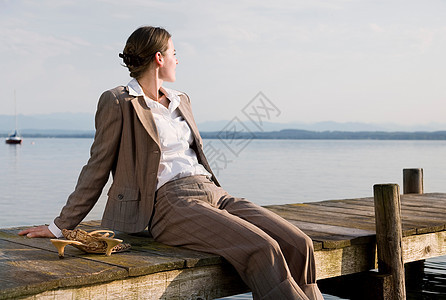 坐在湖边码头上的女人图片