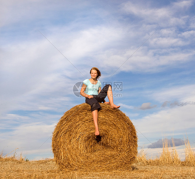坐在干草捆上的女孩图片