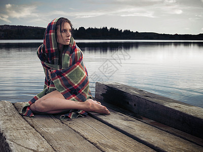 湖边码头上穿着毛毯的女人图片