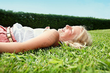 躺在草地上微笑的女孩图片