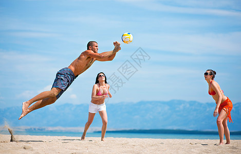 朋友们在沙滩上打排球图片