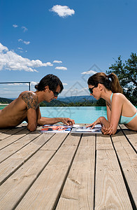 在游泳池里晒日光浴的夫妇图片