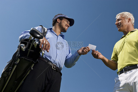 高尔夫球手把他的牌交给球童图片