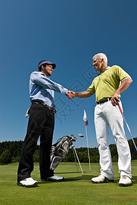 高尔夫球手和球童握手图片