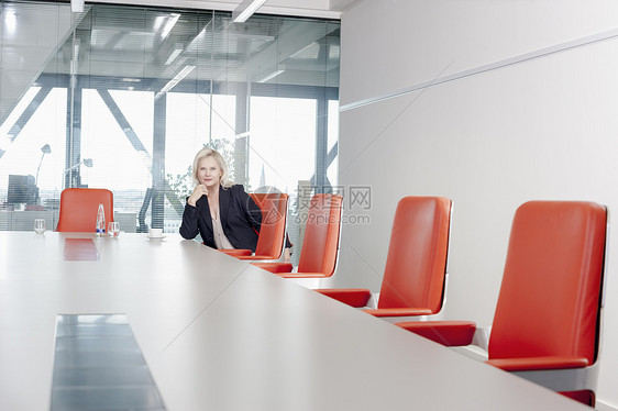 坐在会议室橙色椅子上的女人图片