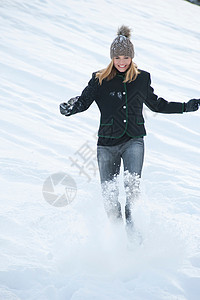微笑的女人在户外踢雪图片