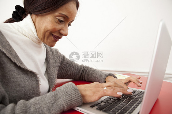 在笔记本电脑上工作的女商人图片