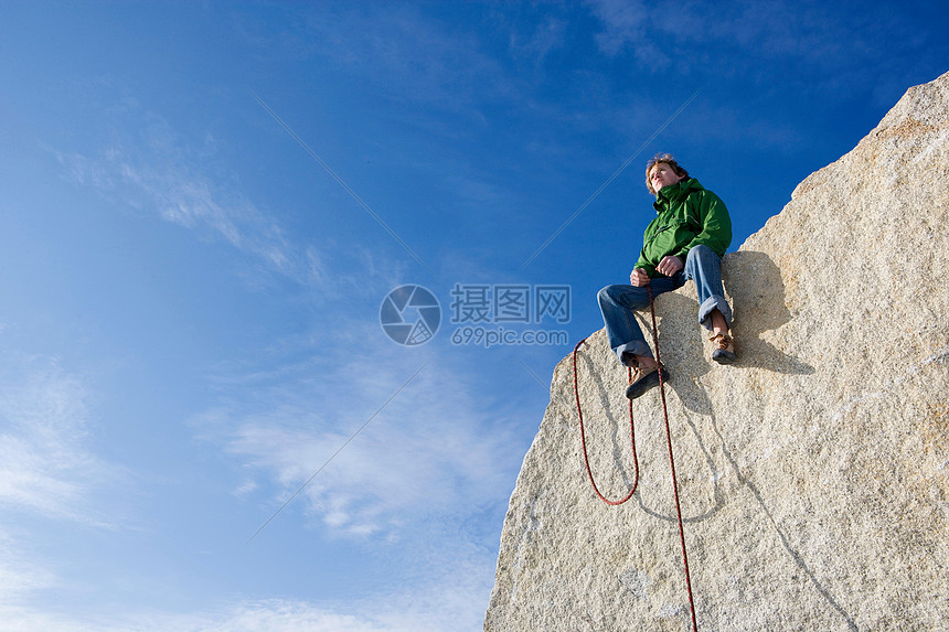 坐在山顶上的登山者图片