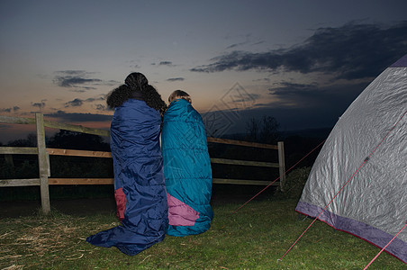 黄昏时分穿着睡袋在野外的男女比图片