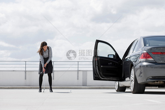 在车附近打高尔夫球的女人图片