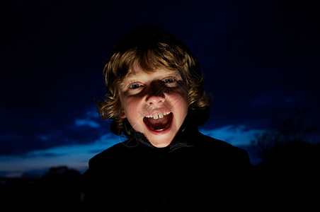 英语四六级男孩用手电筒做鬼脸背景