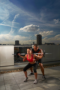 在屋顶上和教练一起锻炼的女人图片