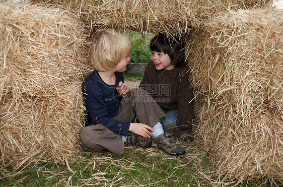 两个男孩在干草包里图片