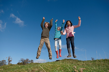 三个孩子在山上跳图片