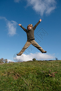 男孩在山上跳跃图片