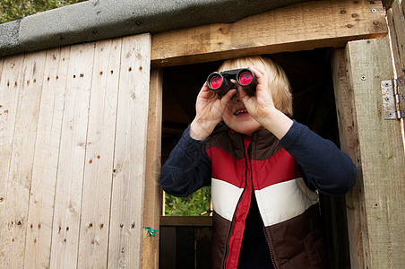 树屋酒店门口带着望远镜在树屋里的小男孩背景