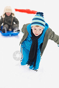 男孩拉着他的朋友在雪橇上图片