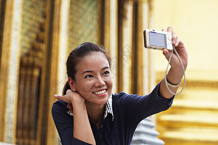 在华丽的寺庙拍照的女人图片