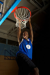 篮球运动员在篮筐上挥杆图片