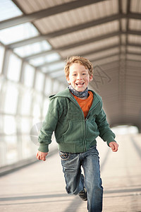 微笑的男孩在城市隧道里奔跑图片