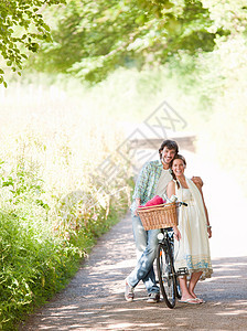 在乡间小路上骑自行车的情侣图片