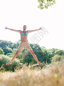 穿比基尼在野外跳跃的女人图片
