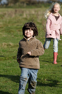 在田里奔跑的男孩和女孩图片