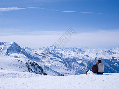 南阿尔卑斯山一对情侣坐在雪地里拥抱背景