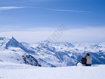 一对情侣坐在雪地里拥抱图片