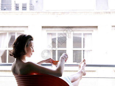 坐在窗前喝酒的女人图片
