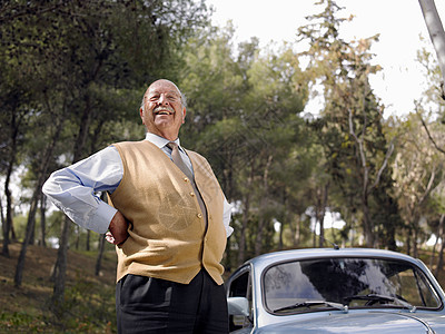 站在车旁的老年男子图片