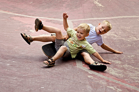 两个孩子在地上玩滑板图片
