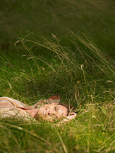 躺草地微笑女性图片