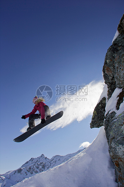 从岩石上跳下来的滑雪运动员图片