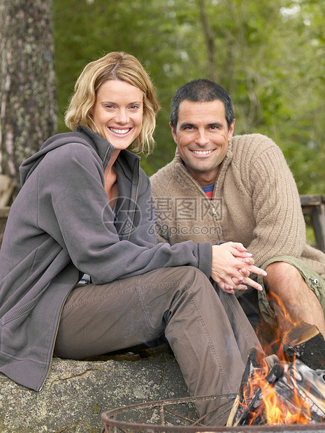 一对在火坑旁微笑的夫妇图片