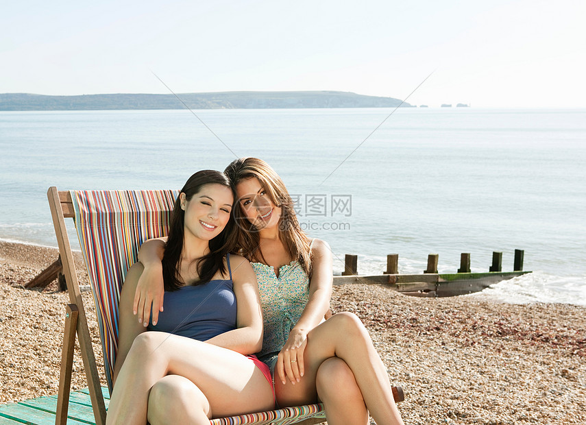 躺椅上两个女人在海滩晒太阳图片