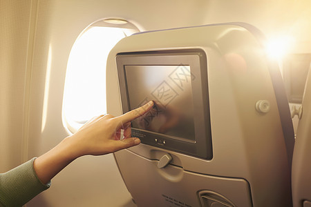 飞机头枕中使用触摸屏的女性手部特写镜头图片
