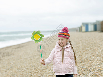 海滩上玩风车的年轻女孩图片
