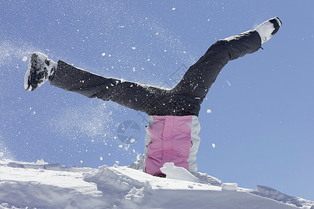 穿滑雪靴的女人在雪地里玩耍图片