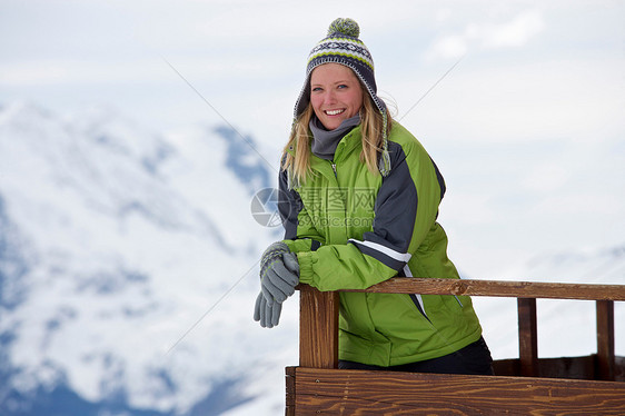 在滑雪小屋阳台上放松的女人图片