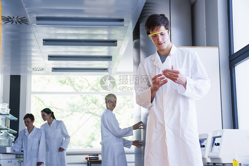 化学系学生在实验室观察试管图片